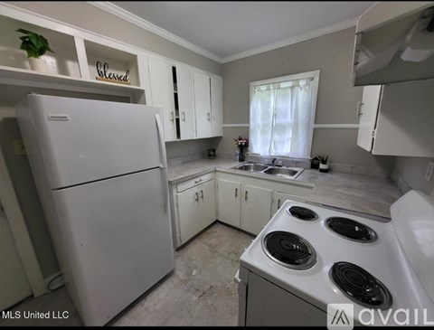 A kitchen with white appliances and cabinets is available on the market.