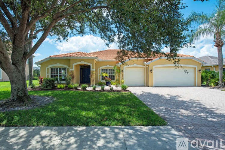 A yellow house with a tree in front of it.