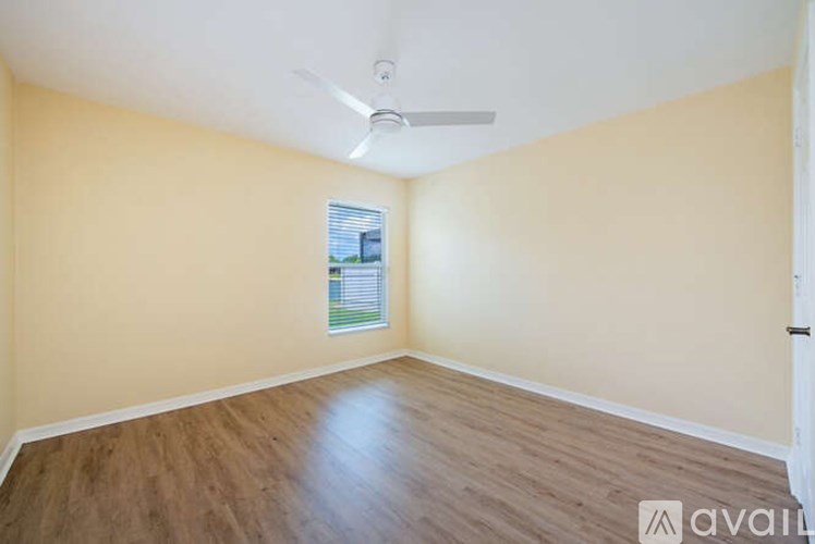 A room with wooden flooring and a ceiling fan.