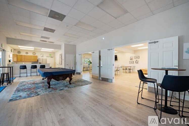 A living room with a pool table and a dining area.