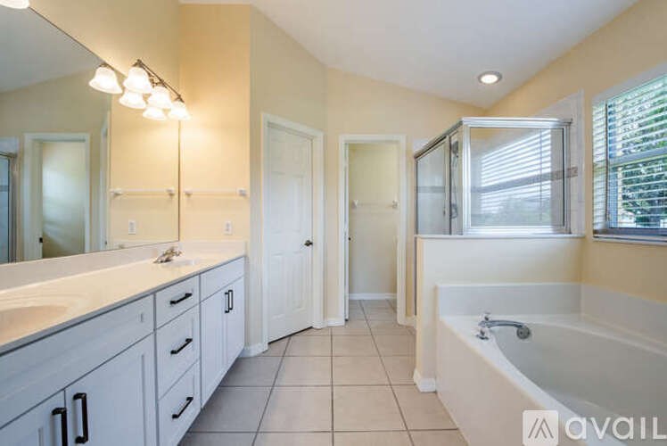 A bathroom with a tub, sink, and mirror.