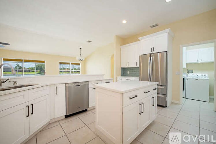 A kitchen with white cabinets and appliances is available for rent.