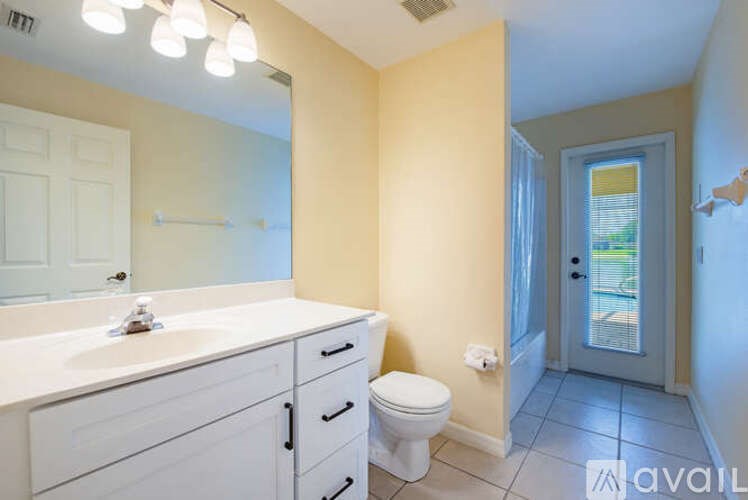 A bathroom with a toilet, sink, and mirror.