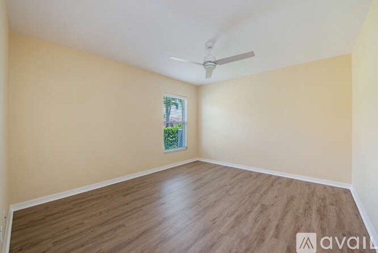 A room with wooden flooring and a ceiling fan.