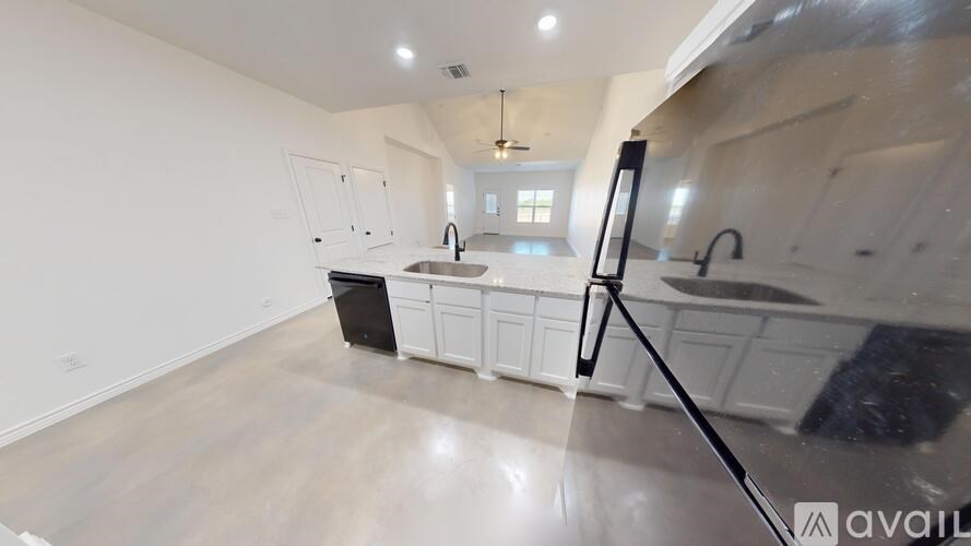 A kitchen with white cabinets and a black dishwasher.
