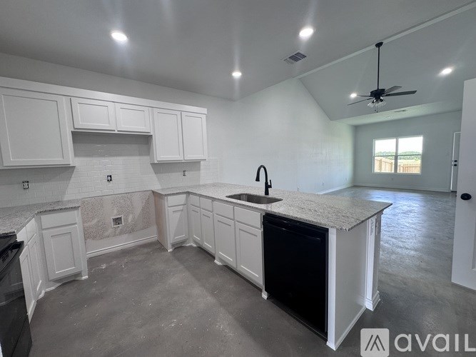 A kitchen with white cabinets and a black dishwasher.