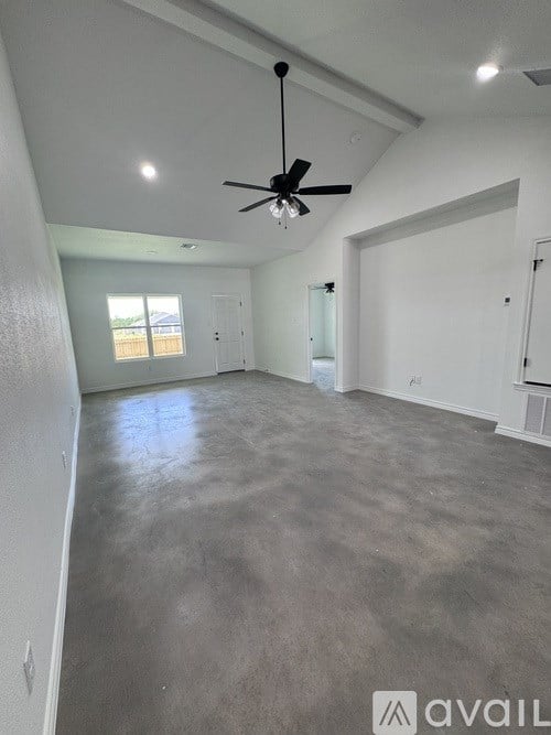 A spacious room with a ceiling fan and a window.