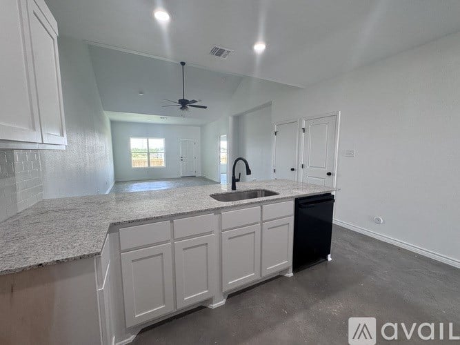 A kitchen with white cabinets and a granite countertop.