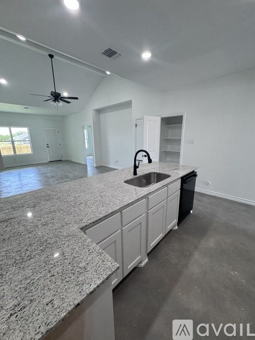 A kitchen with granite countertops and a ceiling fan.