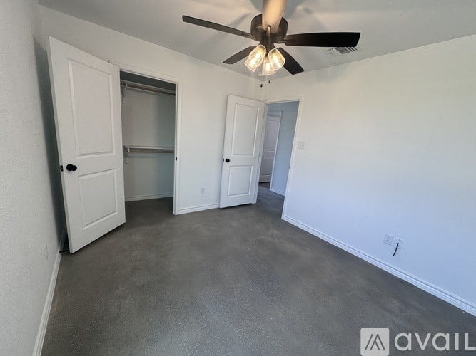 A room with a ceiling fan and three doors.