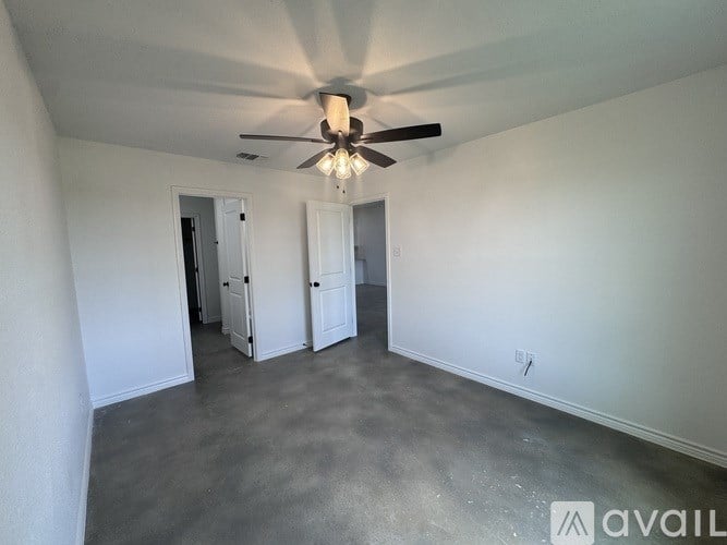 A room with a ceiling fan and two doors.