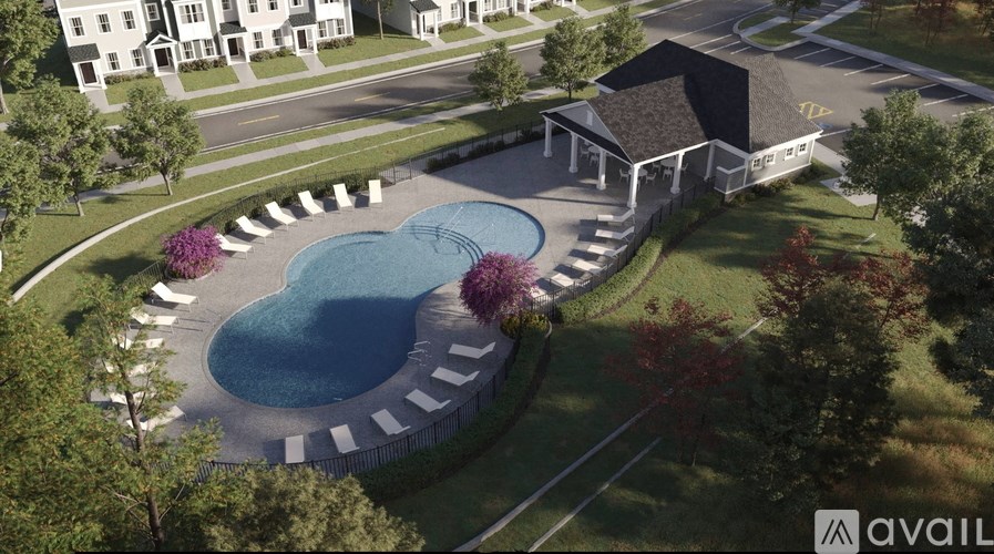 A bird's eye view of a swimming pool surrounded by a concrete border and a small building with a yellow sign on the front.