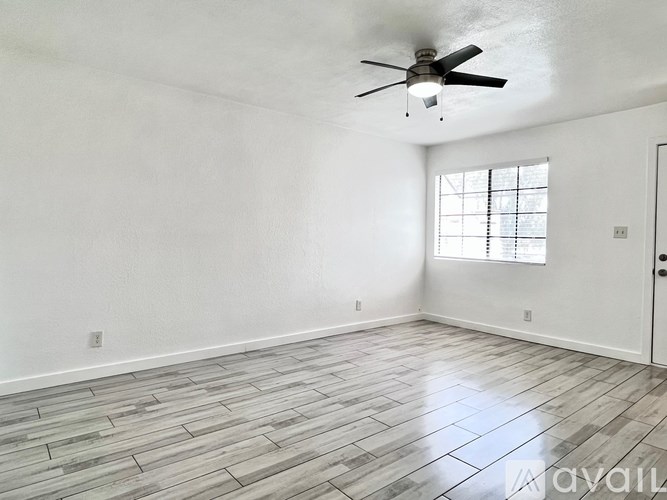 A room with a ceiling fan and a window.