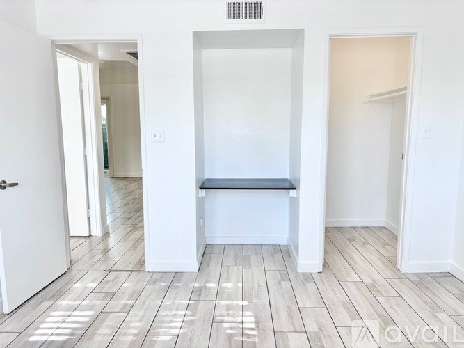 A white room with a bench and a door.