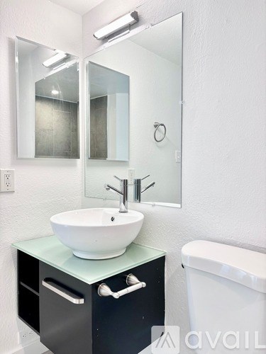 A bathroom with a sink, mirror, and toilet.