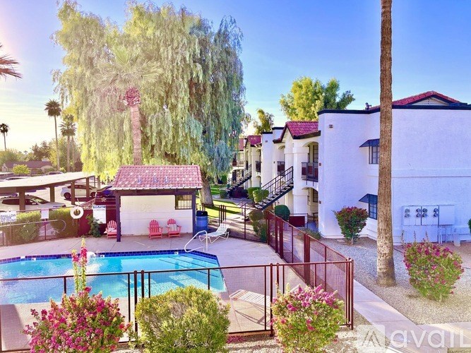 A pool surrounded by a fence and a tree.