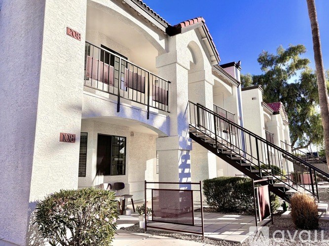 A white building with a red roof and a black railing.