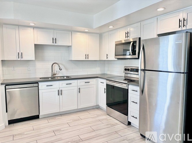 A kitchen with white cabinets and stainless steel appliances.