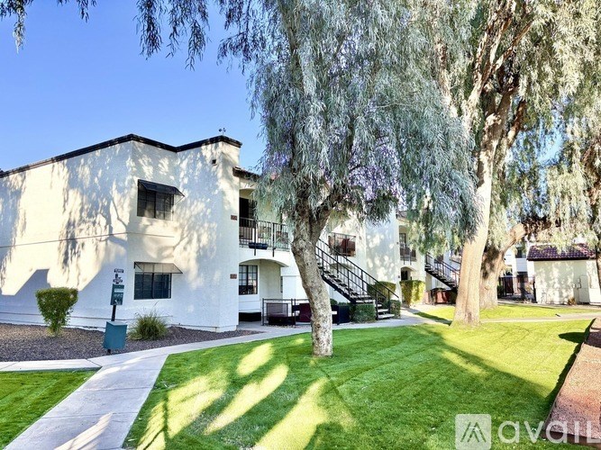 A white building with a tree in front of it.