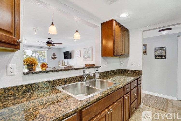 A kitchen with a granite countertop and wooden cabinets.