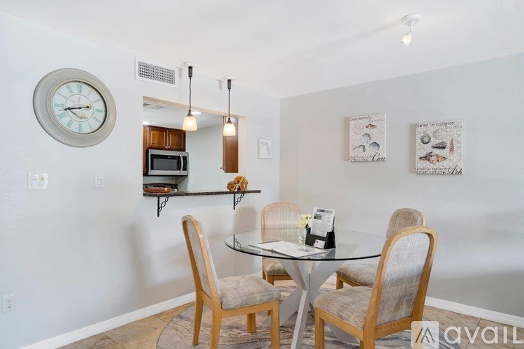 A dining room with a glass table and chairs.