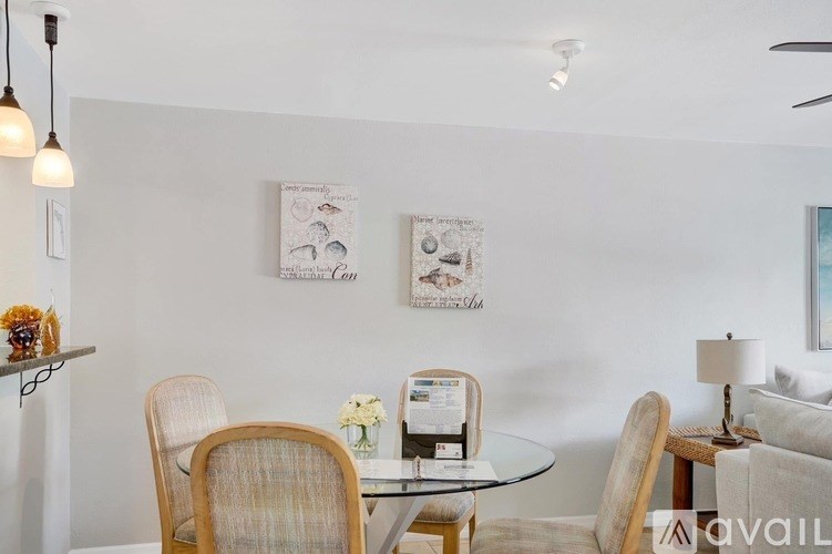 A living room with a glass table and chairs.