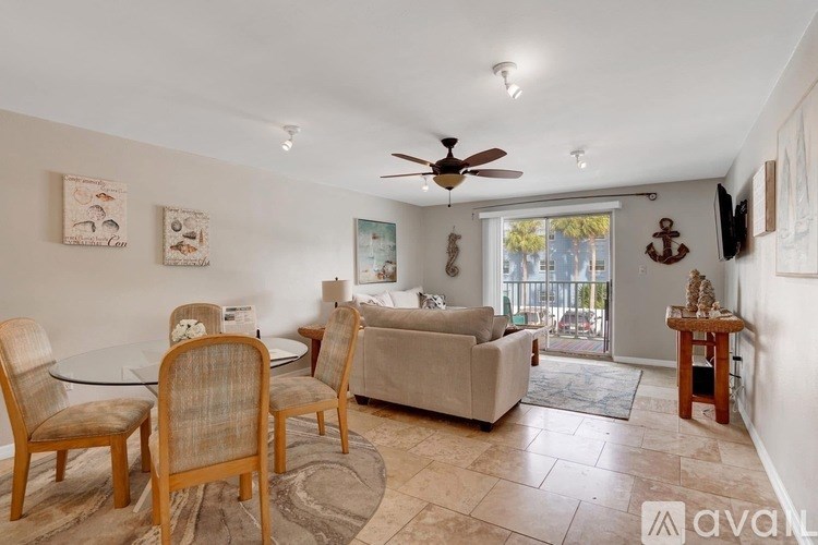 A living room with a couch, chairs, and a ceiling fan.
