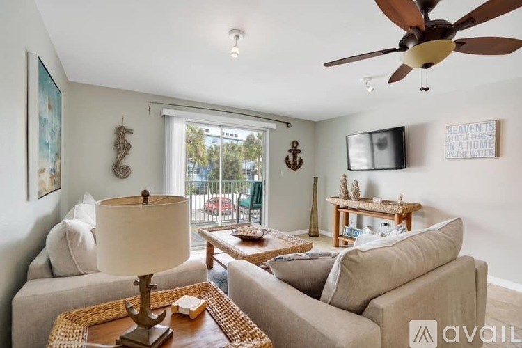 A living room with a beige couch, a wooden coffee table, and a ceiling fan.