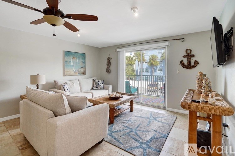 A living room with a beige couch, a wooden coffee table, and a ceiling fan.