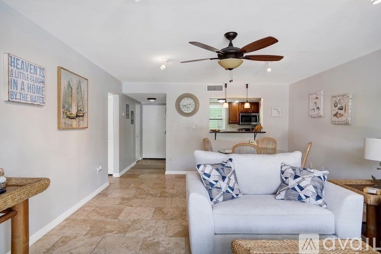 A living room with a white couch and a ceiling fan.