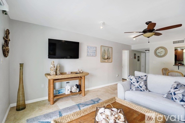 A living room with a white couch and a wooden coffee table.