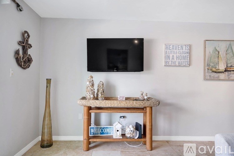 A living room with a flat screen TV mounted on the wall above a wooden table.