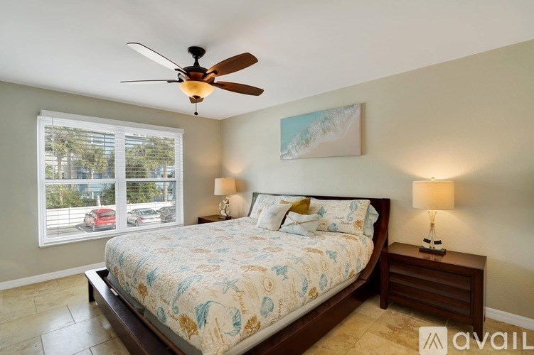 A bedroom with a large bed and a ceiling fan.