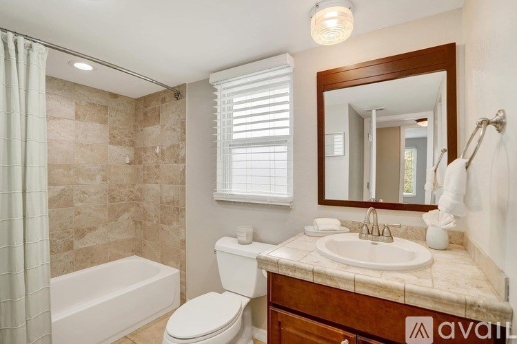 A bathroom with a toilet, sink, and tub.