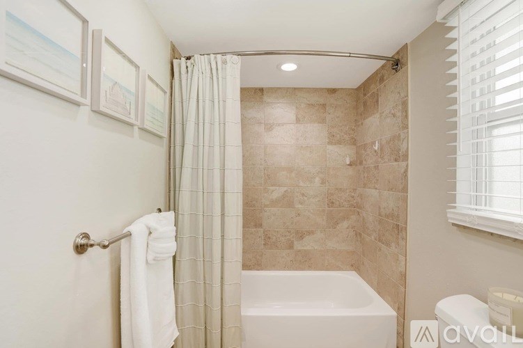 A bathroom with a white tub and a shower with a glass door.