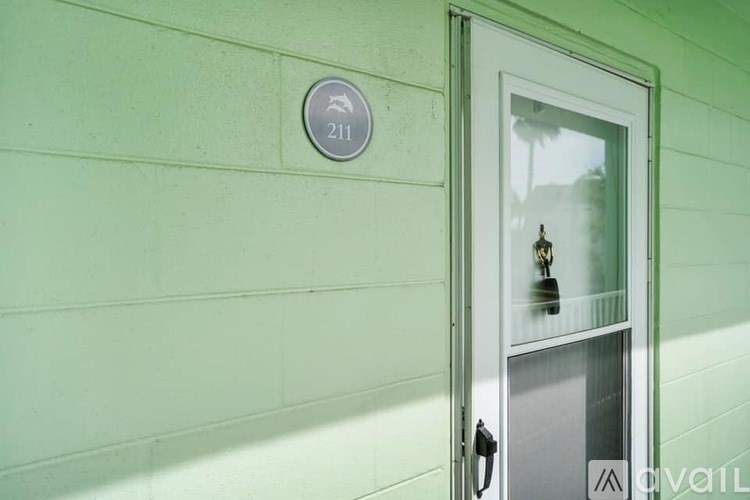 A green wall with a round sign that says 211 on it.