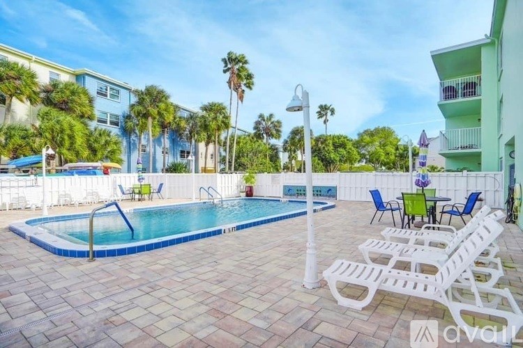 A pool surrounded by white chairs and palm trees.