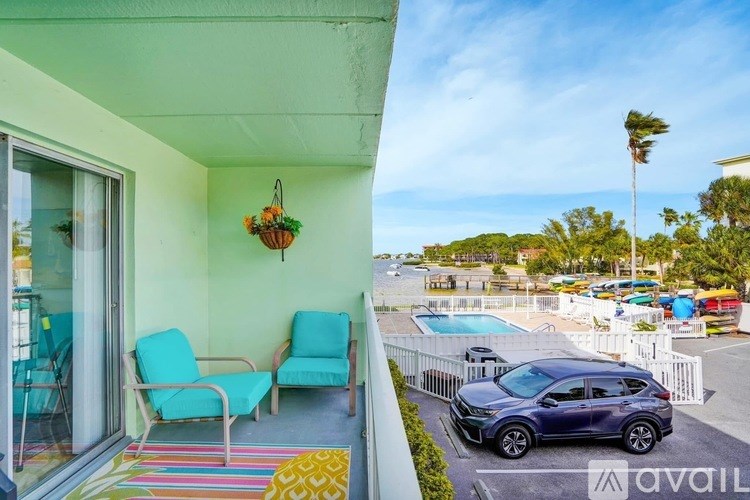 A balcony with a blue chair and a hanging plant.