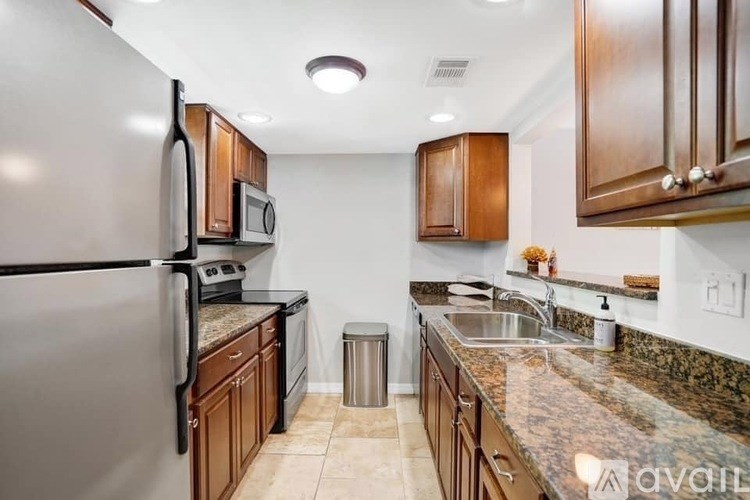 A kitchen with granite countertops and wooden cabinets.