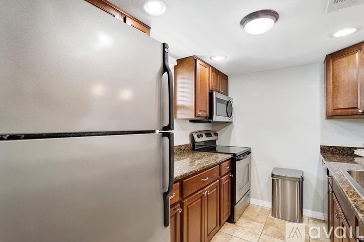 A kitchen with a refrigerator, microwave, and oven.