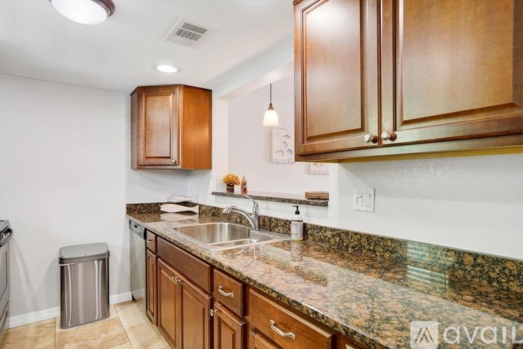 A kitchen with brown cabinets and granite countertops.