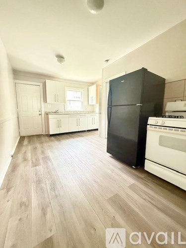 A kitchen with a black fridge and white stove.