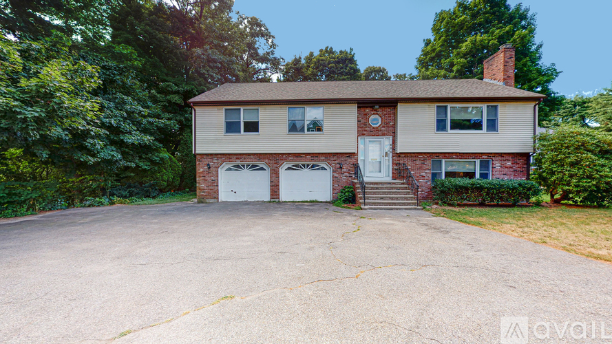 A two-story house with a garage and a brick chimney.