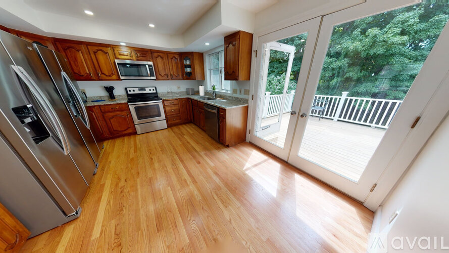 A house with a white fence and a deck with a chair.