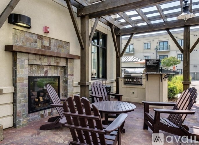 A patio with a fireplace and chairs.