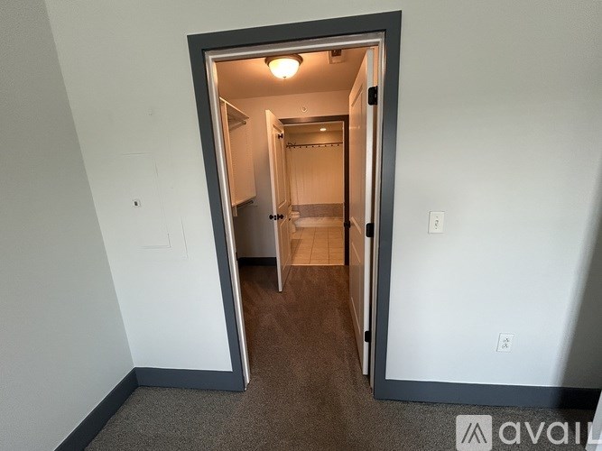 A room with a carpeted floor and a doorway leading to another room.