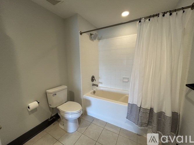 A white toilet sits next to a bathtub in a bathroom.