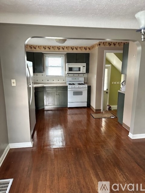 A kitchen with a wooden floor and a small dining area.