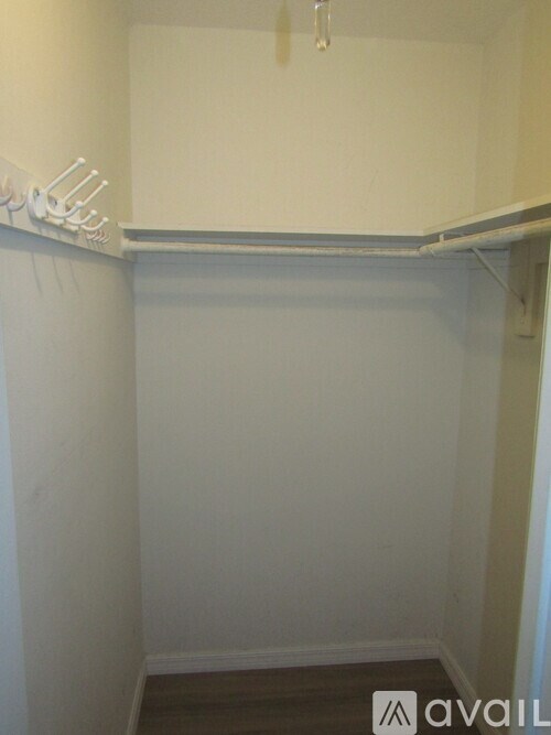 A small, empty room with a white wall and a white shelf.