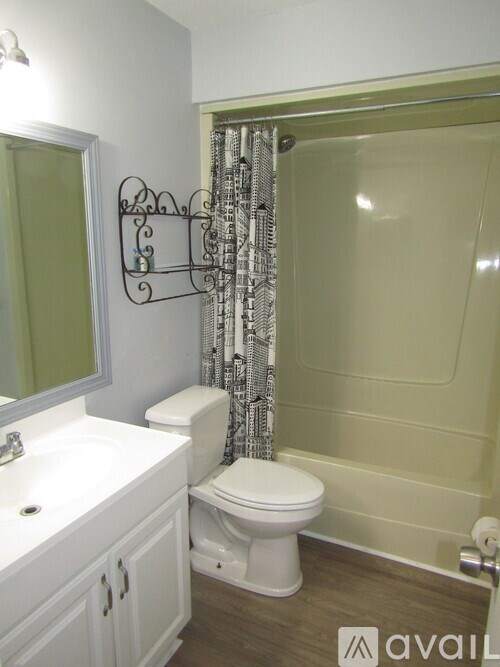 A bathroom with a toilet, sink, and shower.